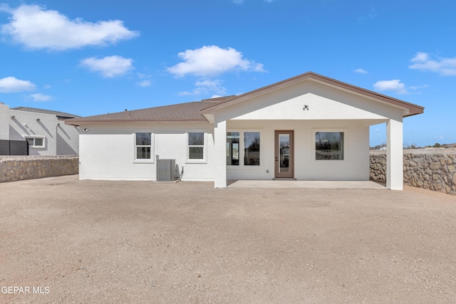 rear view of house featuring cooling unit, a patio, and stucco siding