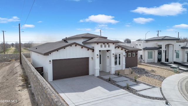 view of front facade featuring concrete driveway, fence, and an attached garage