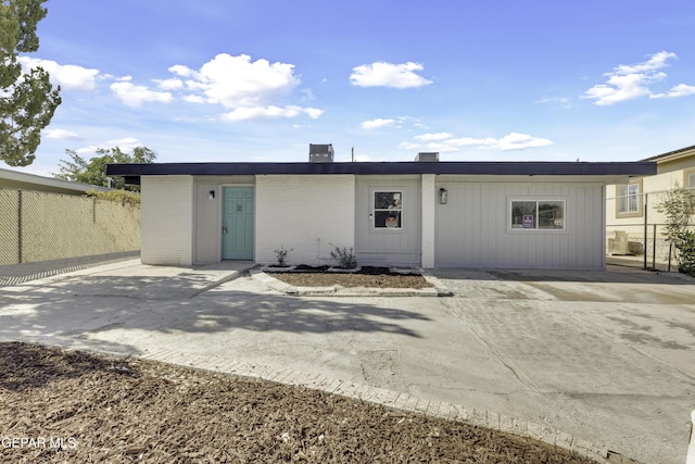 rear view of property featuring fence and brick siding