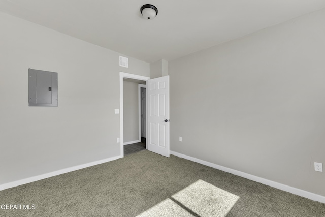 carpeted spare room featuring electric panel and baseboards