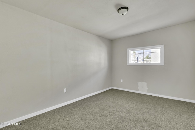 unfurnished room with carpet floors and baseboards