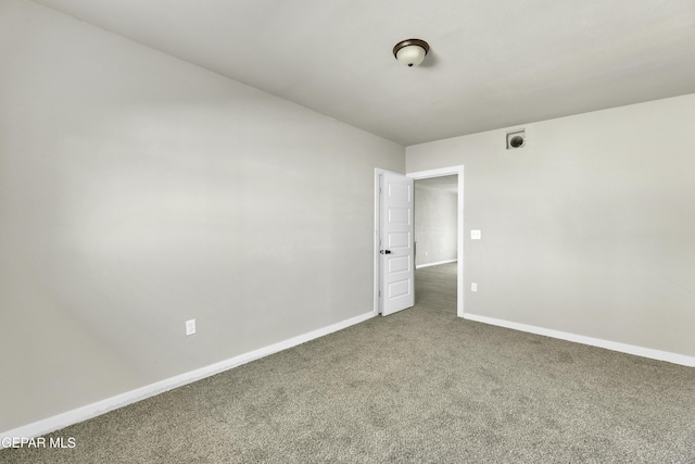 unfurnished room featuring carpet and baseboards