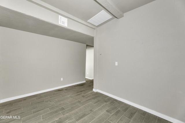 unfurnished room featuring baseboards, visible vents, and wood tiled floor