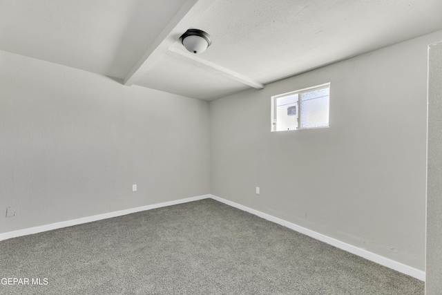 spare room with carpet floors, beam ceiling, a textured ceiling, and baseboards