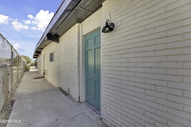 view of home's exterior with a patio area, brick siding, and fence