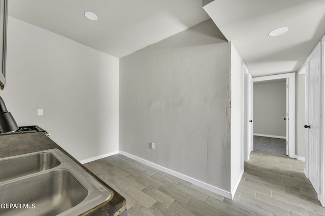 kitchen featuring baseboards, dark countertops, and wood tiled floor