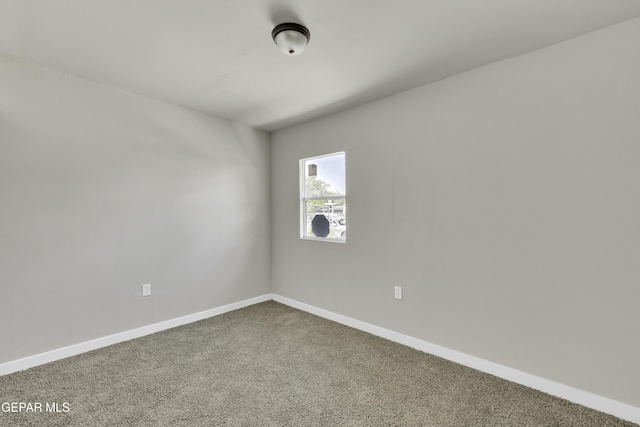 empty room with carpet and baseboards