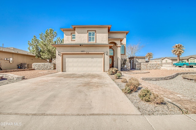 view of front of house featuring a garage, driveway, and stucco siding