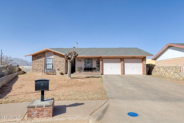 view of front of house with driveway, an attached garage, a shingled roof, and brick siding