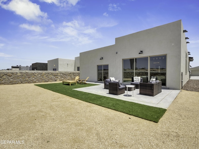 back of house featuring a patio area, an outdoor living space, and stucco siding