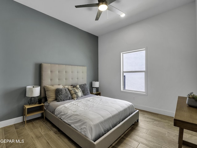 bedroom with a ceiling fan, baseboards, and wood finished floors