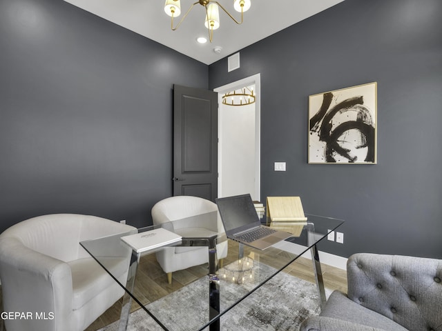 interior space featuring an inviting chandelier, baseboards, and wood finished floors