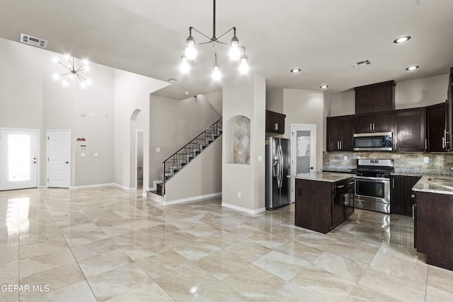 kitchen featuring a center island, tasteful backsplash, visible vents, appliances with stainless steel finishes, and open floor plan