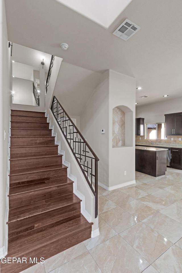 stairs with recessed lighting, visible vents, and baseboards