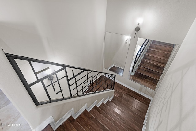 staircase with baseboards and wood finished floors