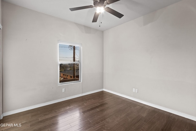 empty room featuring dark wood-style floors, ceiling fan, and baseboards