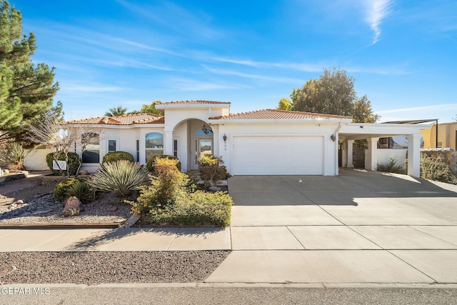 mediterranean / spanish home with driveway, stucco siding, an attached garage, and a tiled roof