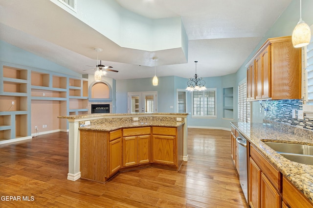 kitchen featuring open floor plan, a fireplace, dishwasher, and light wood finished floors