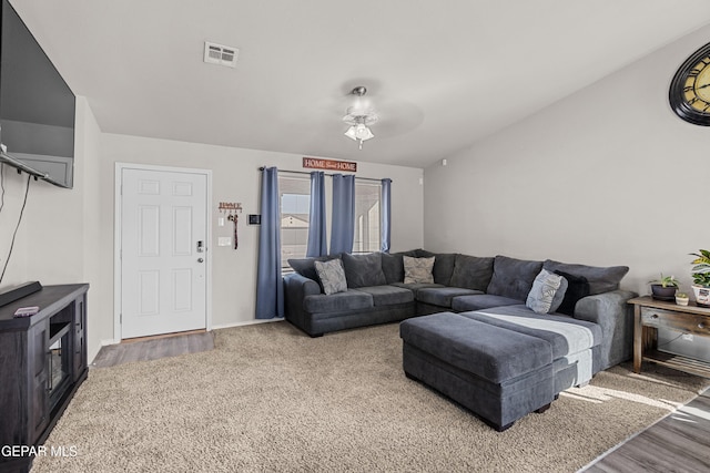 living room featuring lofted ceiling, wood finished floors, visible vents, and a ceiling fan