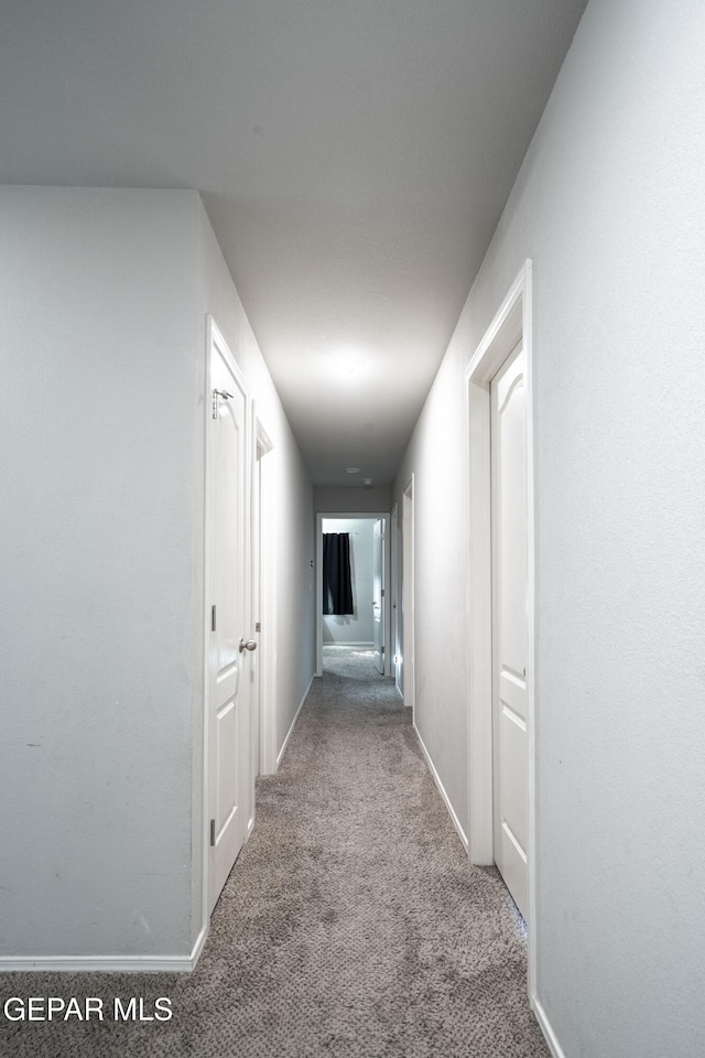 hall with carpet flooring and baseboards