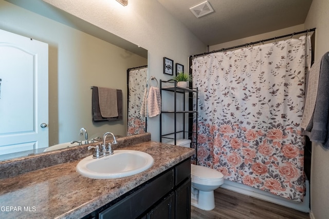 full bathroom with toilet, wood finished floors, vanity, visible vents, and a shower with curtain