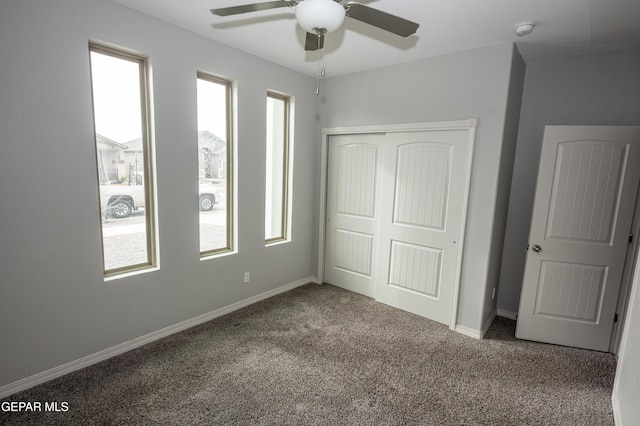 unfurnished bedroom with ceiling fan, a closet, carpet, and baseboards