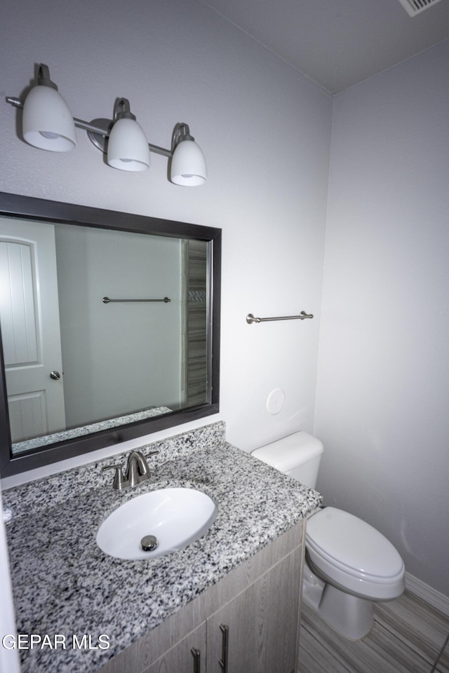 bathroom with baseboards, a sink, visible vents, and toilet