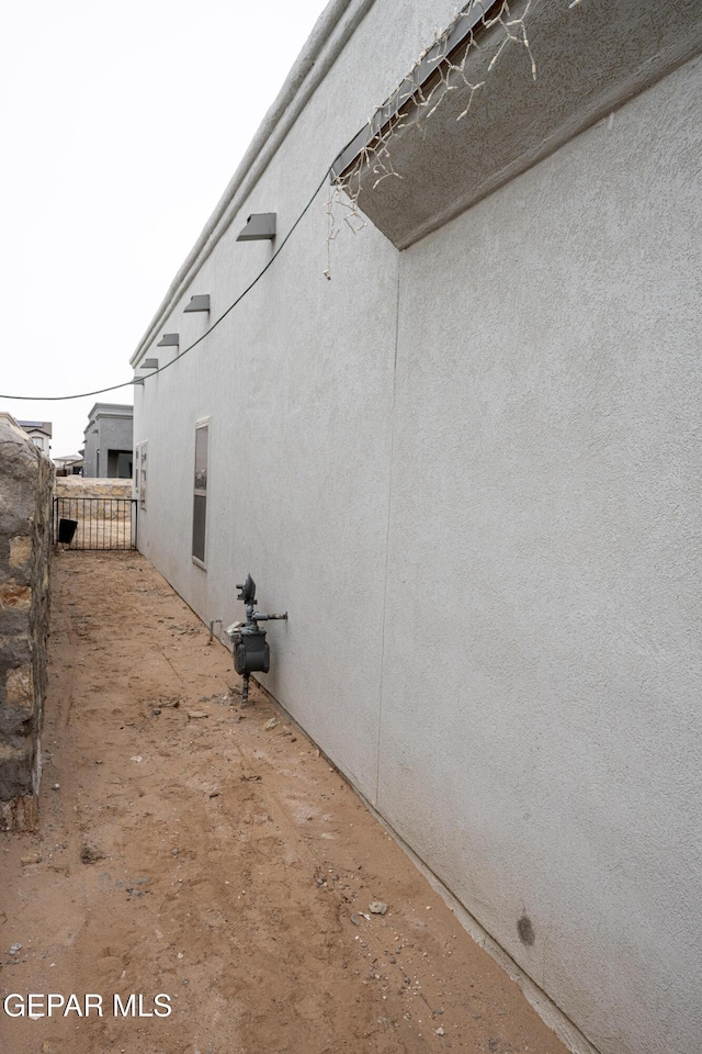 view of property exterior featuring fence and stucco siding