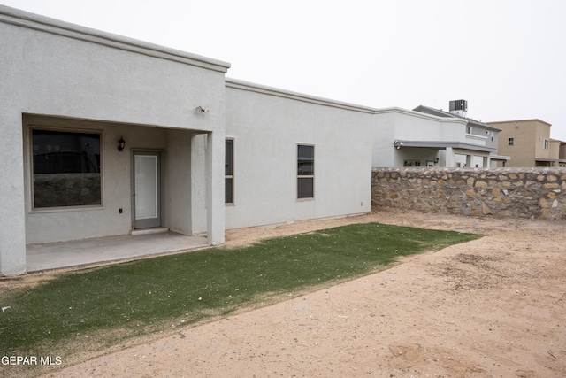 rear view of house with a patio area and stucco siding