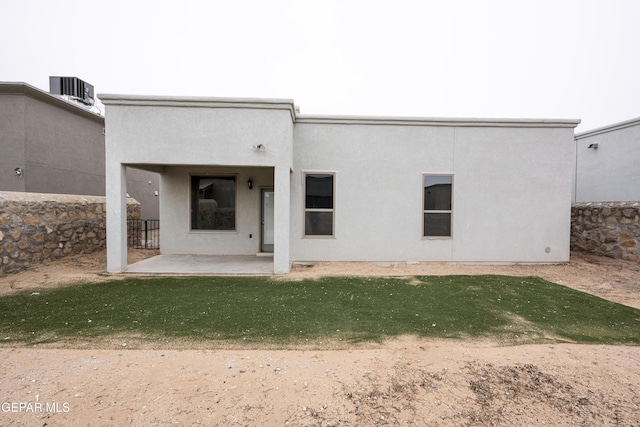 rear view of property with a patio area, central AC, and stucco siding