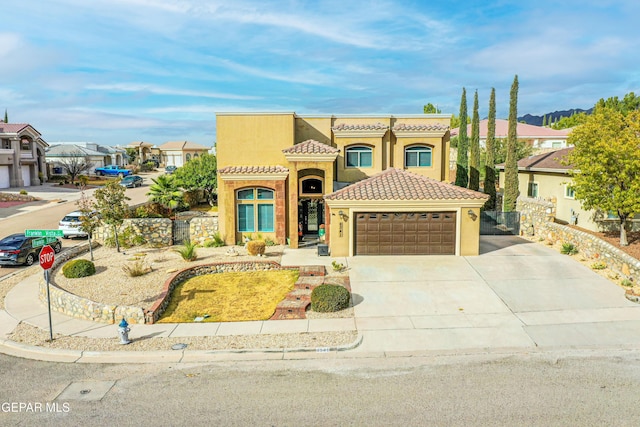 view of front of house with a garage, a tile roof, concrete driveway, a residential view, and stucco siding