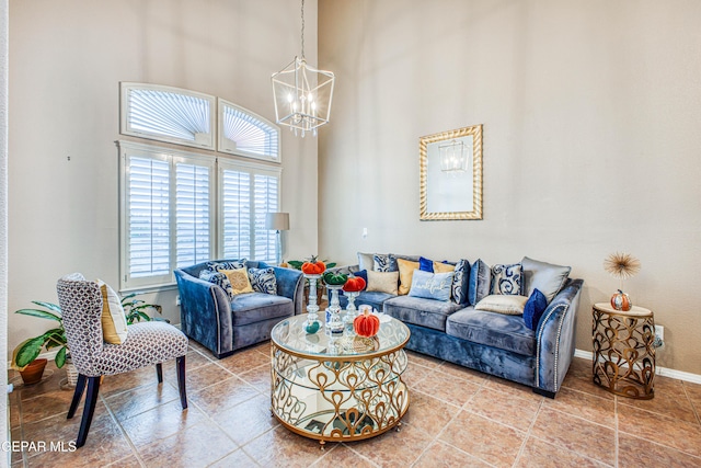 living room featuring baseboards, a high ceiling, light tile patterned floors, and a notable chandelier