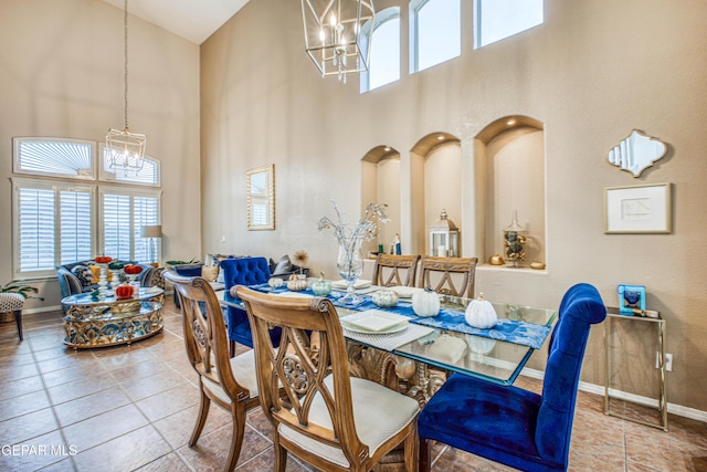 tiled dining area featuring a healthy amount of sunlight, baseboards, and an inviting chandelier