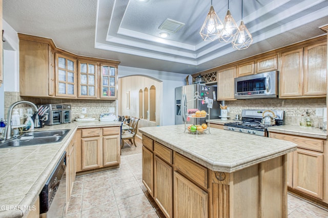 kitchen with arched walkways, stainless steel appliances, a sink, visible vents, and a tray ceiling