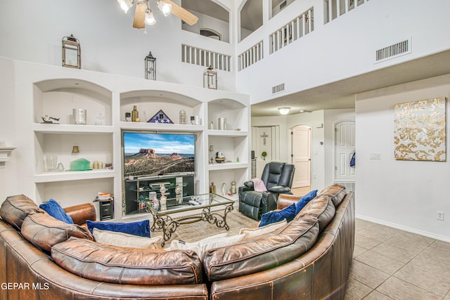 living area featuring built in features, visible vents, and a ceiling fan