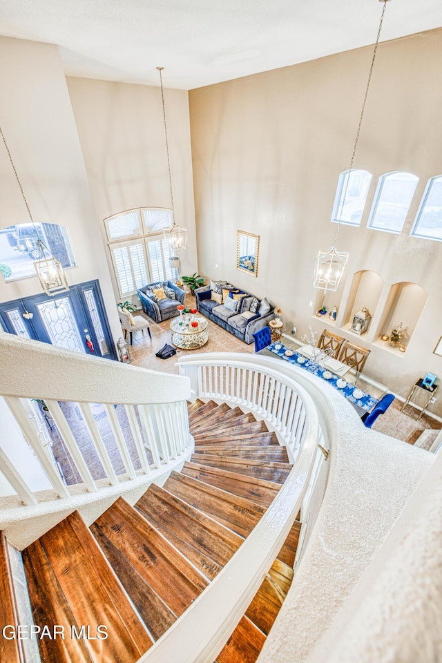 stairs featuring a high ceiling and a notable chandelier