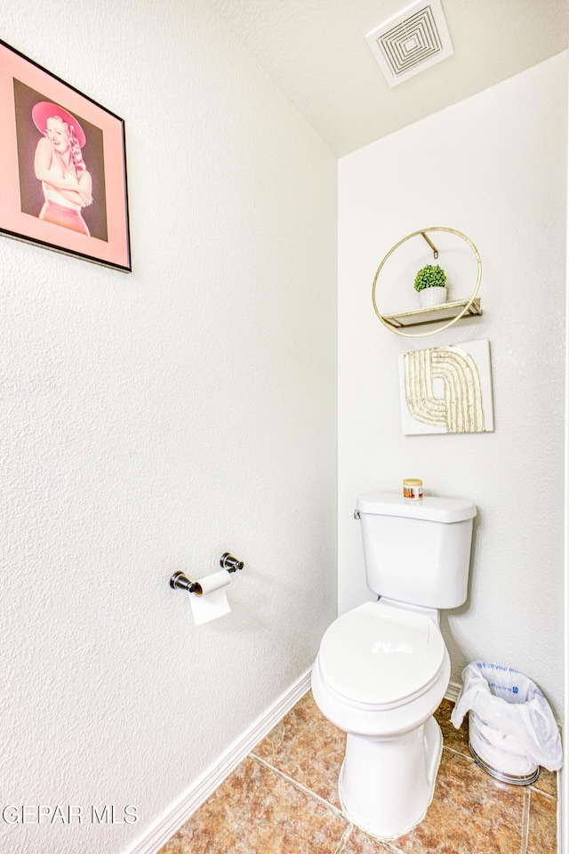 bathroom featuring toilet, baseboards, visible vents, and tile patterned floors