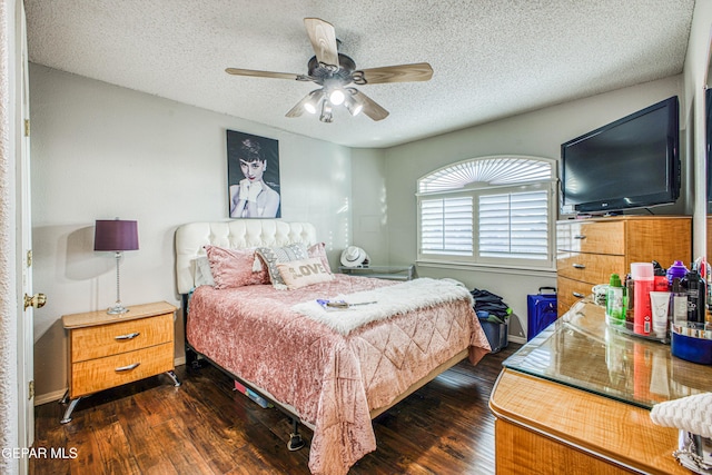 bedroom with a textured ceiling, dark wood-style flooring, a ceiling fan, and baseboards