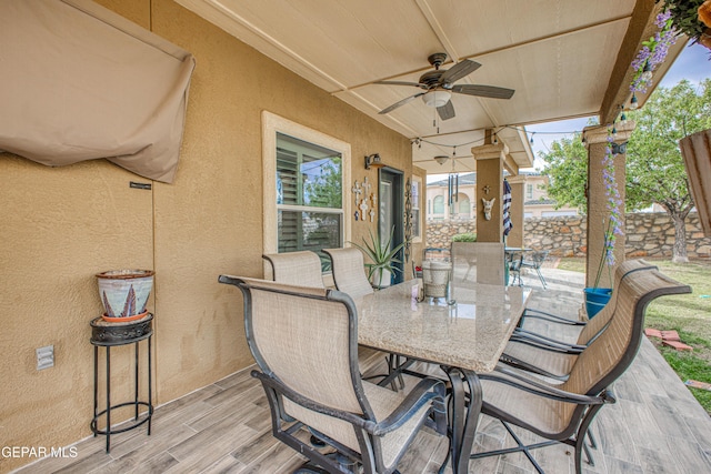 view of patio / terrace with ceiling fan, outdoor dining space, and fence