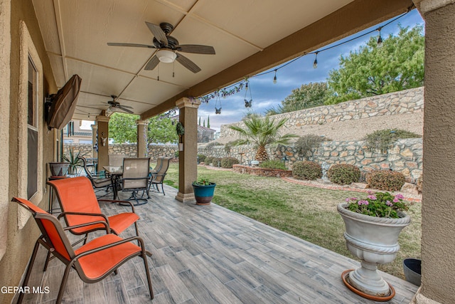 view of patio with a ceiling fan, outdoor dining area, and a fenced backyard