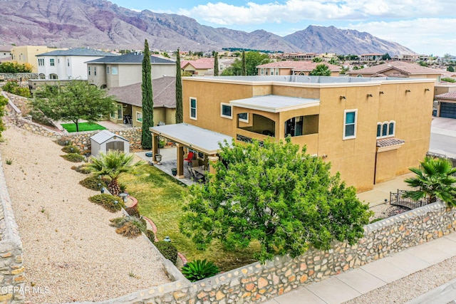 exterior space with a patio, a fenced backyard, a residential view, a mountain view, and stucco siding