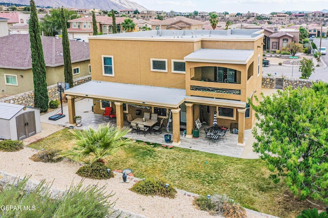 rear view of house featuring a residential view, a storage unit, outdoor dining area, and an outbuilding