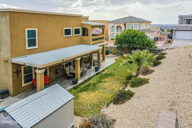 back of property with a patio and stucco siding