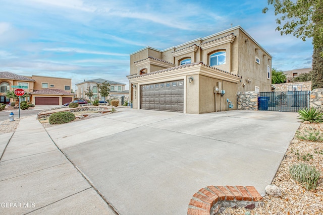 view of home's exterior featuring a garage, driveway, a gate, and stucco siding