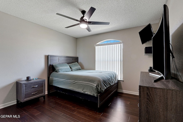 bedroom with a ceiling fan, baseboards, a textured ceiling, and dark wood-style flooring