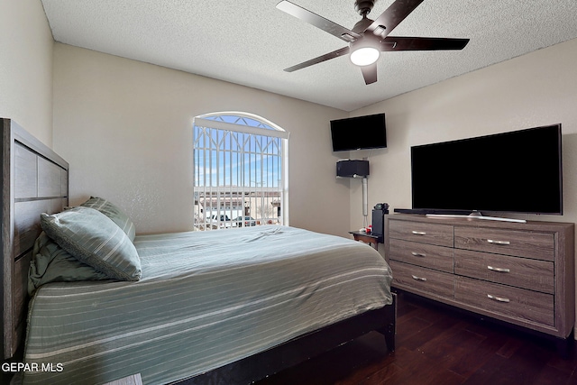 bedroom featuring ceiling fan, dark wood-type flooring, and a textured ceiling