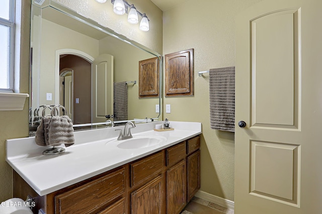 bathroom featuring vanity and a textured wall