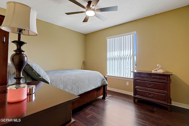 bedroom featuring ceiling fan, baseboards, dark wood-style flooring, and a textured ceiling