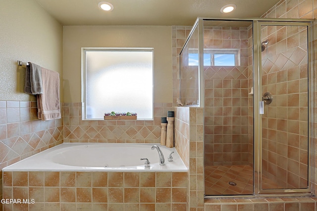 bathroom with a stall shower, a bath, and recessed lighting