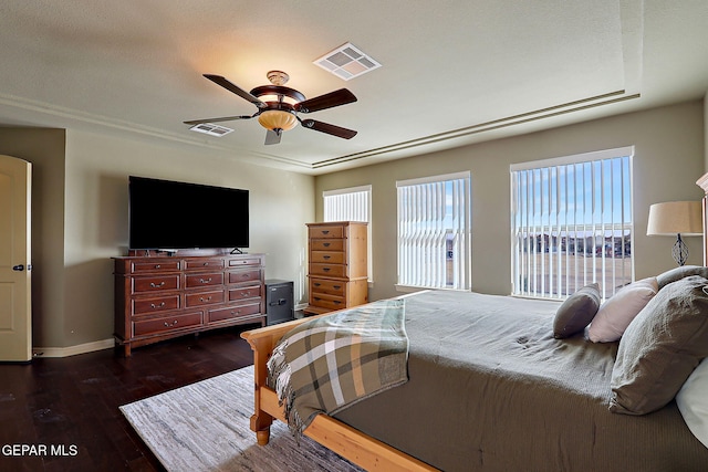 bedroom with dark wood finished floors, baseboards, visible vents, and a ceiling fan